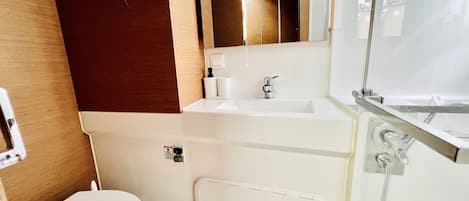 A bathroom with a toilet, sink, and shower.