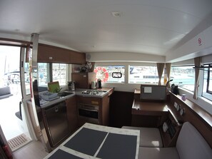 A compact galley with a stove, sink, and a small refrigerator. - Sun-Kissed Sailing Adventure in Sibenik, Croatia (Rogoznica)