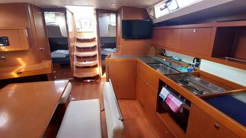 A compact kitchen with a stove, sink, and storage cabinets.