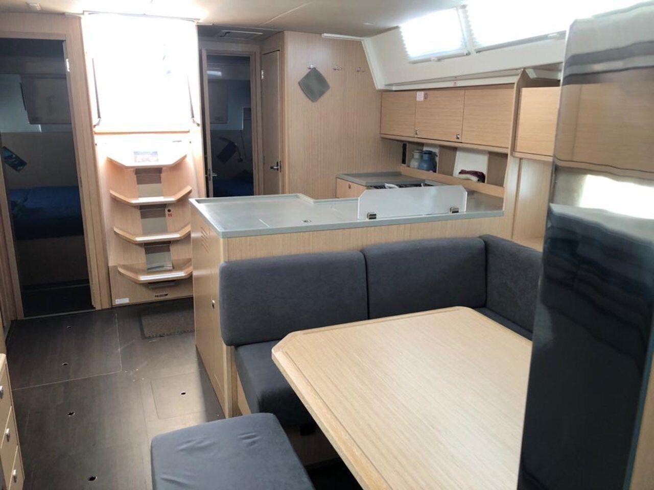 Un intérieur de camping-car compact comprenant un coin cuisine, un espace salon et une petite fenêtre.
