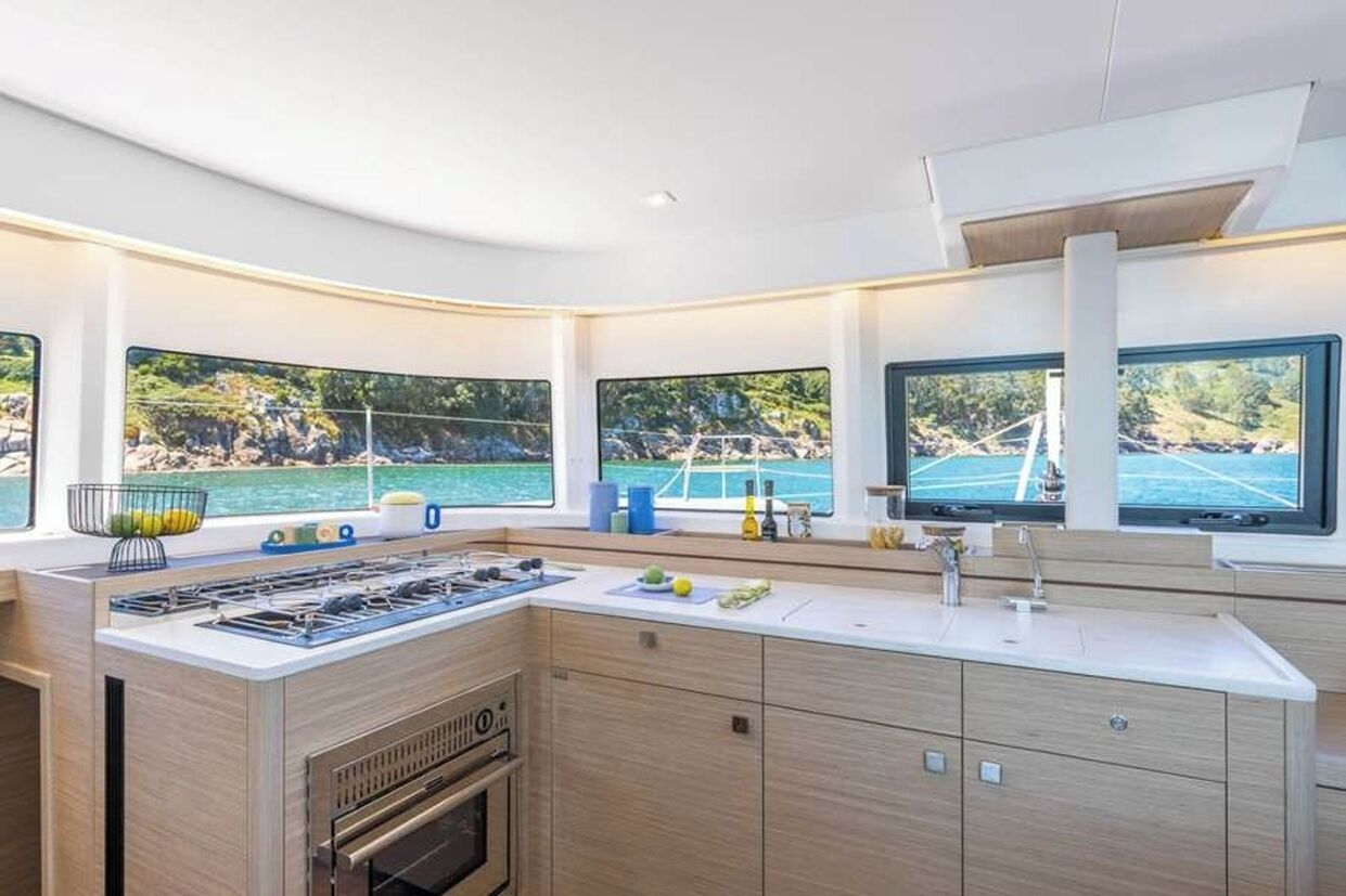 Una cocina moderna con una isla grande, horno empotrado y varios ventanales con vistas panorámicas.