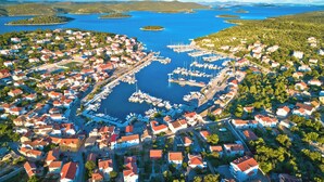 An aerial view of a coastal town with a marina, residential buildings, and surrounding water bodies. - Sibenik Sun and Beach Sailing Extravaganza: A Croatian Coastal Adventure (Jezera)