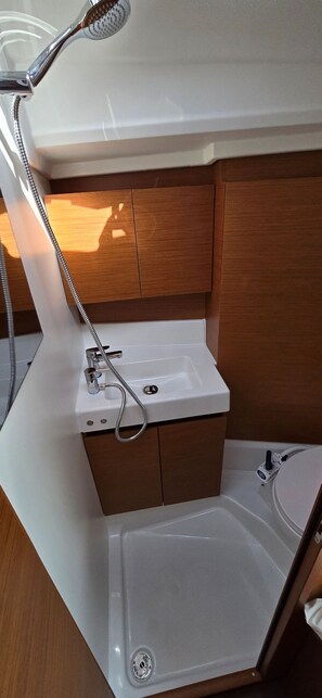 A bathroom with a shower, a sink, and a toilet. - Sun-Kissed Sailing Adventure in Istria, Croatia (Pula)