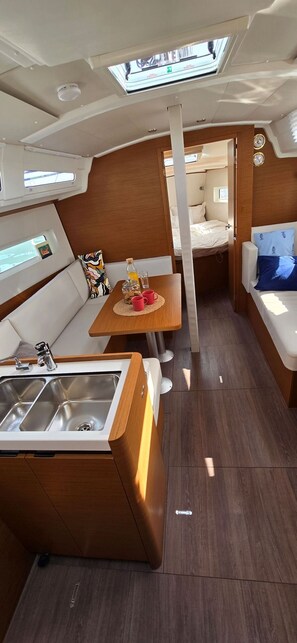 A compact interior with a kitchenette, a dining area, and a sleeping berth. - Sun-Kissed Sailing Adventure in Istria, Croatia (Pula)