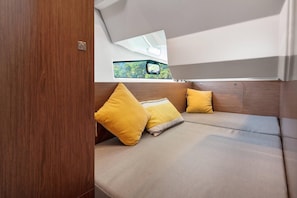 A cozy interior with a cushioned seating area, a window with a view, and a wooden door. - Sun-Kissed Sailing Adventure in Istria, Croatia (Pula)