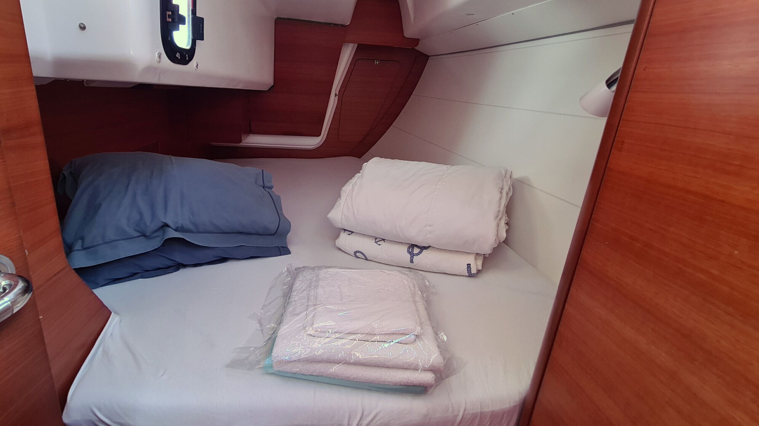 A compact cabin with a bed, pillows, and a small storage area.