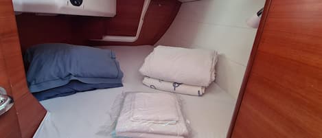 A compact cabin with a bed, pillows, and a small storage area.