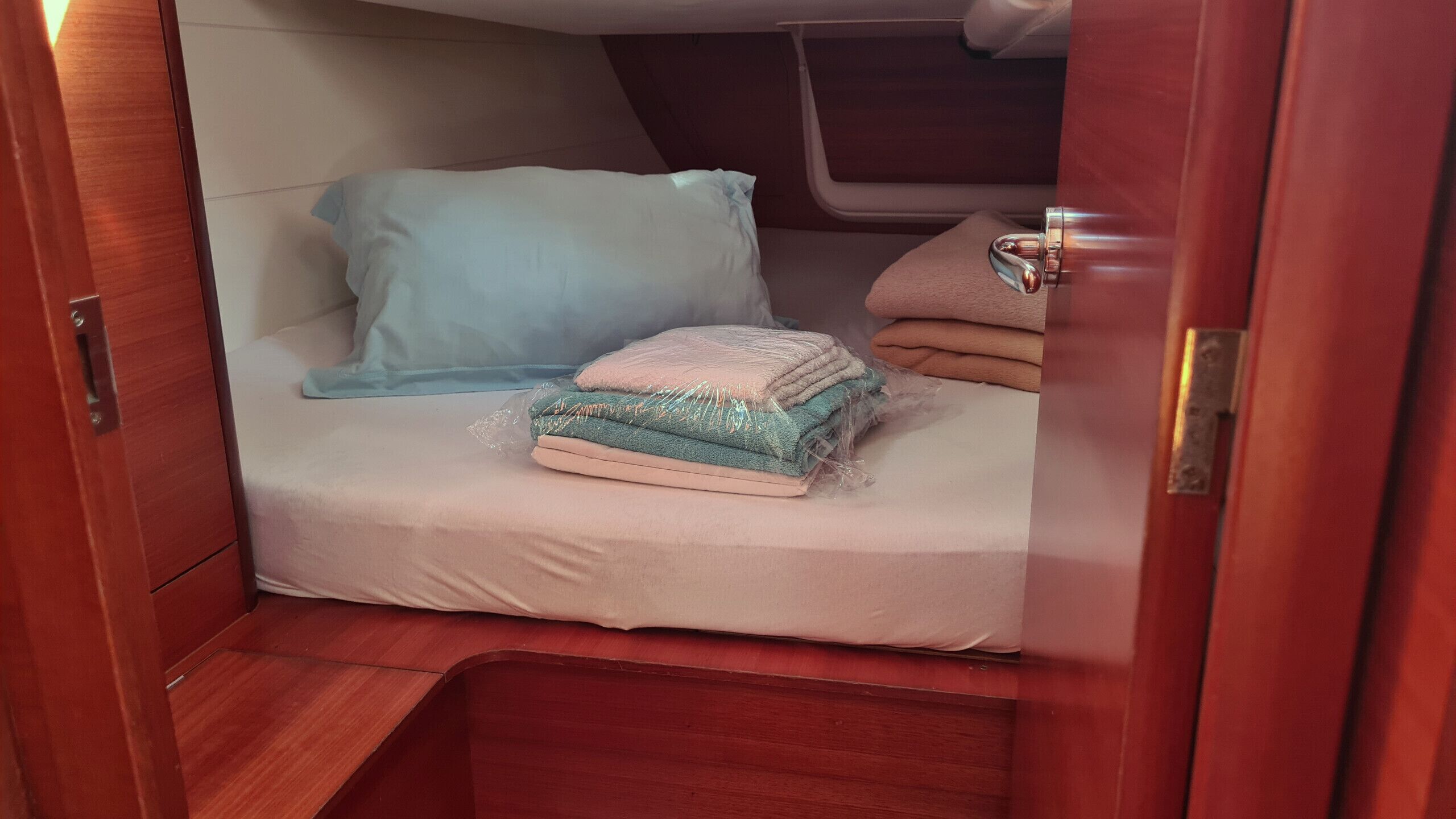 Una cabaña compacta con literas, un espacio pequeño de almacenamiento y un ventanal.