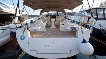 Eine VUSCHI Yacht mit überdachter Deckfläche, mehreren Steuerständen und einer zentralen Sitzgruppe.