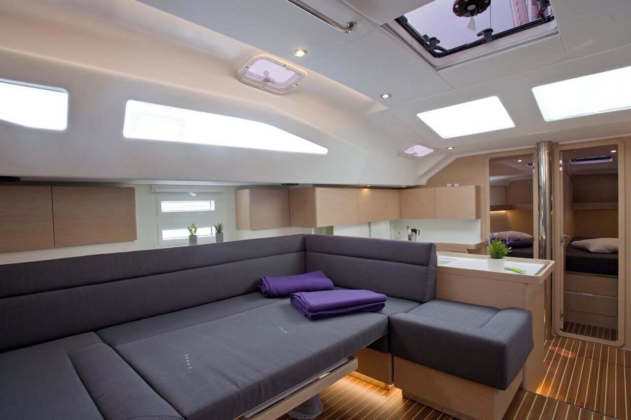 Ein modernes Interieur mit einer Couch, einer kleinen Küchenzeile und einem Schlafbereich.
