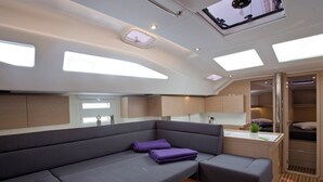 A modern interior with a sofa, a small kitchen area, and a sleeping area. - Sun-Kissed Sailing Adventure in Istria, Croatia (Pula)