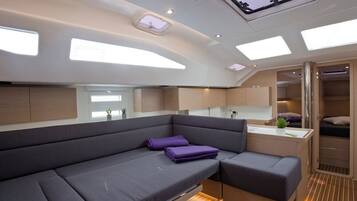 Ein modernes Interieur mit einer Couch, einer kleinen Küchenzeile und einem Schlafbereich.