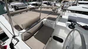 Ein Bootsdeck mit gepolsterten Sitzgelegenheiten, einem Steuer und einer Ankerwinde.
