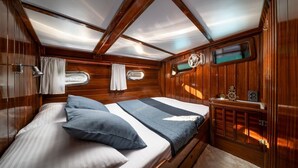 Eine Hütte mit einem Bett, einem kleinen Tisch und einem Fenster.