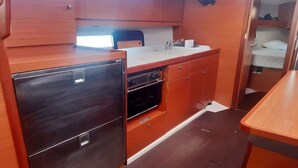 Eine kleine Küche mit Kühlschrank, Backofen und Spüle.