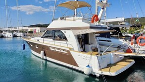 A yacht docked at a marina with a clear sky, other boats in the background, and a calm water surface. - Sun-Kissed Sailing Adventure in Zadar, Croatia (Bibinje)