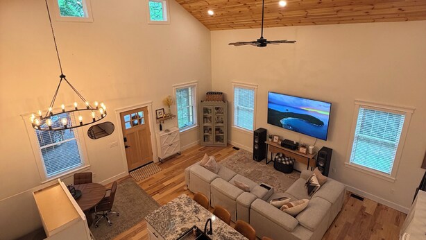 A spacious living area with a wooden ceiling, a large TV, and a cozy seating arrangement. - Cozy 2-bedroom house in adorable Mohnton with AC (Mohnton)