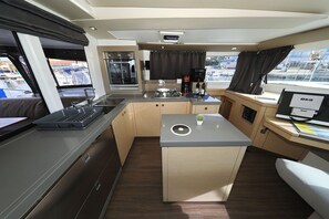 A compact kitchen with a central island, a built-in oven, and a coffee maker. - Sun-Kissed Sailing Adventure in Zadar, Croatia (Biograd na moru)