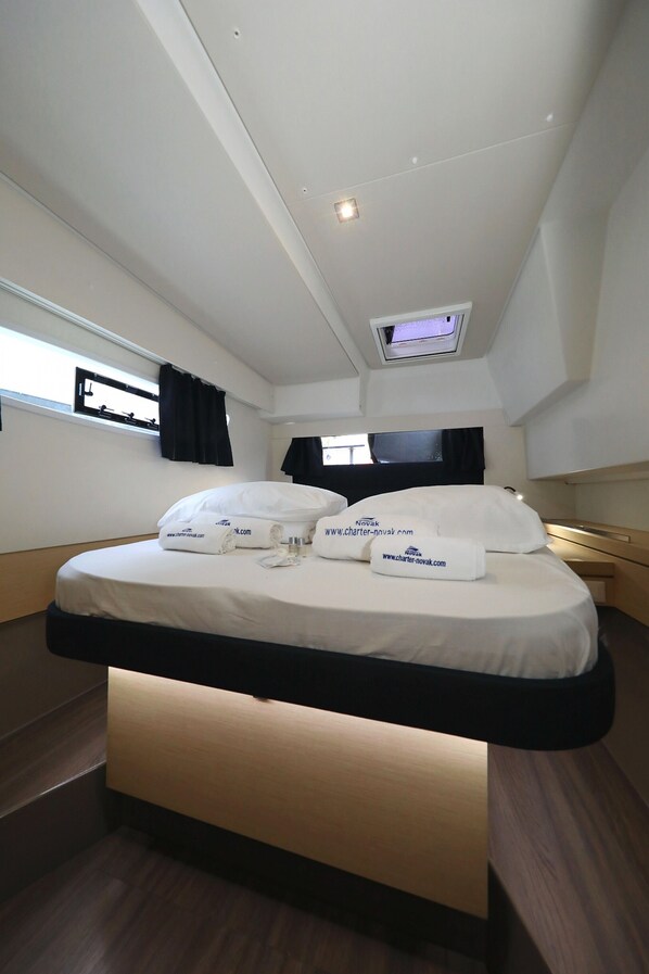 A modern hotel room with a bed, a TV, and a window.
