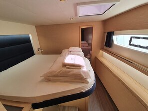 A compact room with a bed, a small window, and a door leading to another space. - Sun-Kissed Sailing Adventure in Zadar, Croatia (Biograd na moru)