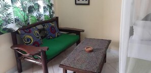Una habitación con un sofá verde, una mesita y un objeto decorativo sobre ella.