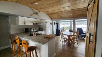 Une cuisine avec un îlot central, des chaises en bois et une table à manger avec des chaises.