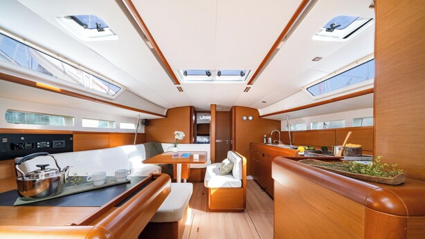 A yacht interior with a dining area, seating, a kitchen, and a control panel. - Sun-Kissed Sailing Adventure in the Saronic Islands (Nea Peramos)