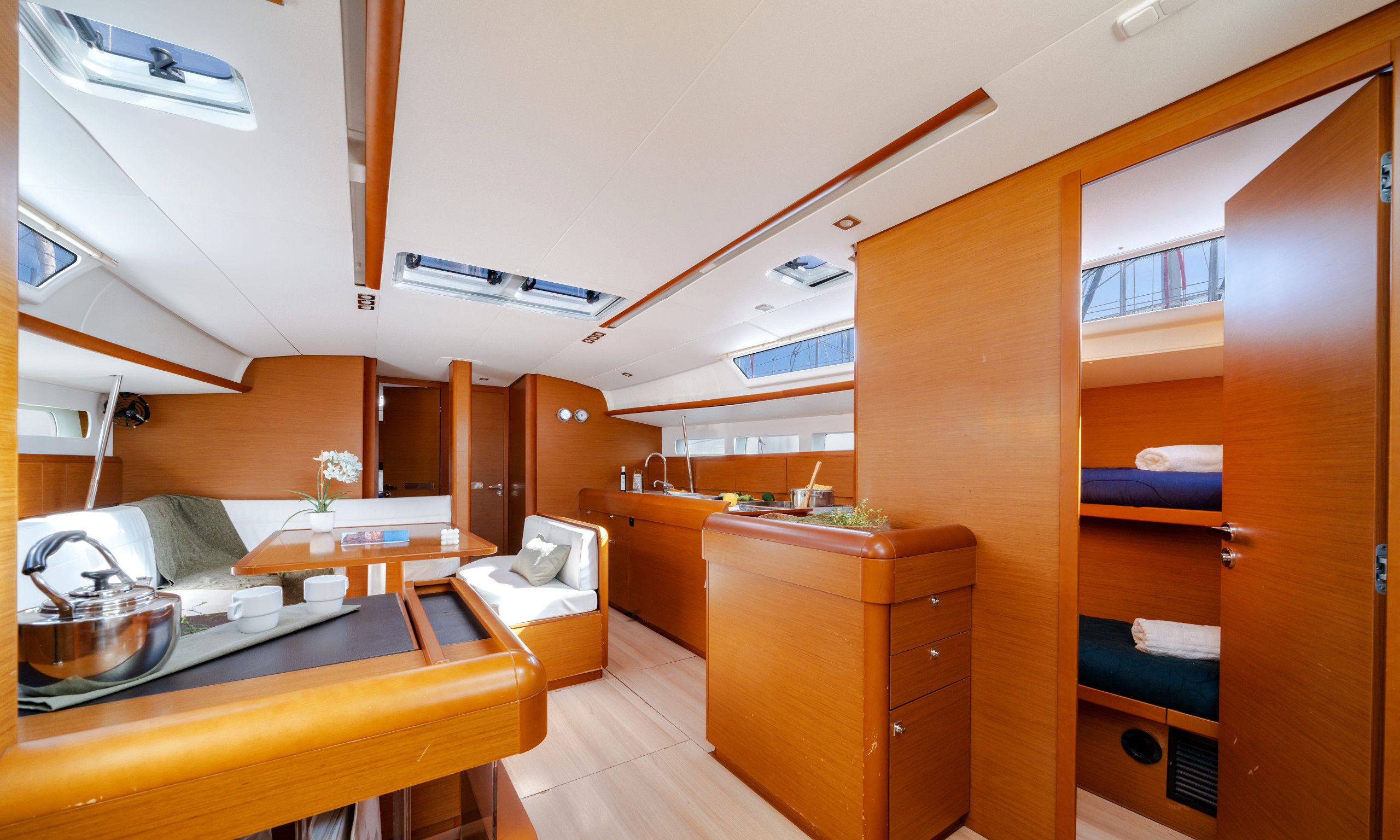 A compact, well-lit interior with a dining area, kitchenette, and sleeping quarters.