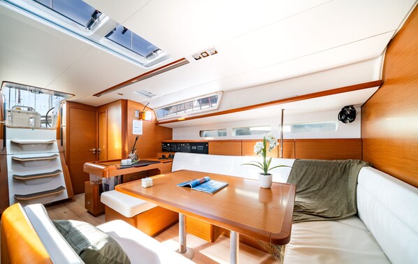 A compact, well-lit interior with a dining area, seating, and a control panel.