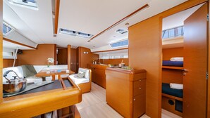 A compact, well-lit interior with a kitchenette, dining area, and sleeping quarters. - Sun-Kissed Sailing Adventure in the Saronic Islands (Nea Peramos)