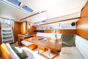 A compact, well-lit interior with a dining area, seating, and a control panel. - Sun-Kissed Sailing Adventure in the Saronic Islands (Nea Peramos)
