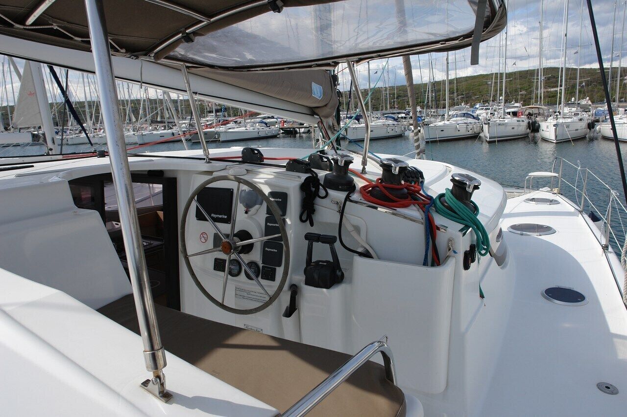 Ein Bootsdeck mit Steuer, Winschen und einem Rettungsring.
