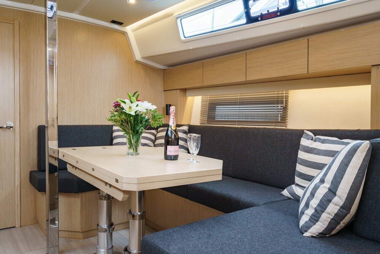 A compact living space with a sofa, a small table, and a window with blinds.