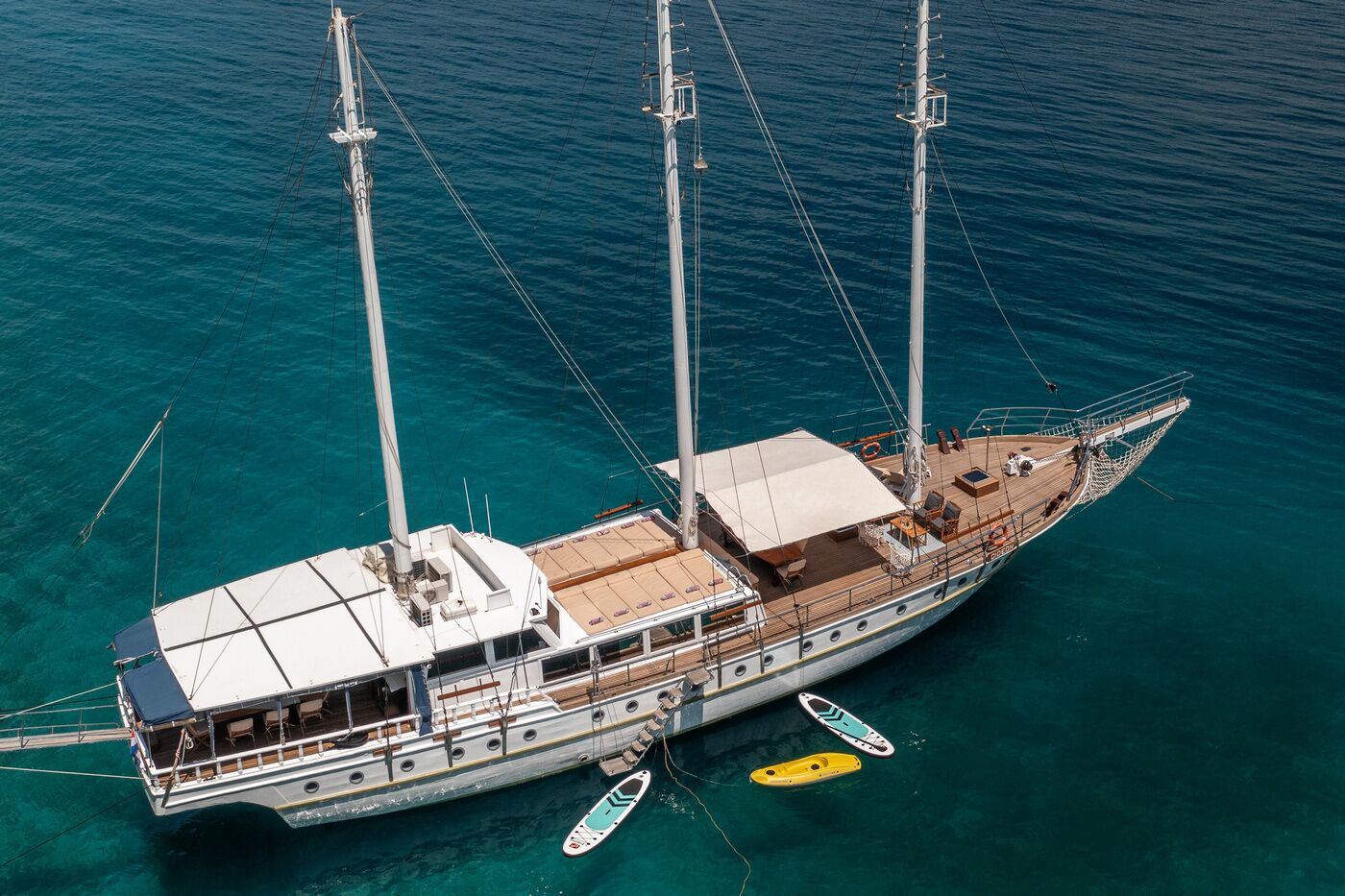 A large sailing yacht with multiple decks, a cabin area, and a spacious deck with seating.