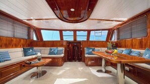 A luxurious yacht interior with a central seating area, a dining table, and large windows providing views. - Sun-kissed Sailing Adventure in Split-Dalmatia, Croatia (Trogir)