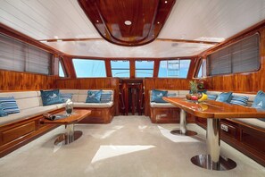 A luxurious yacht interior with a central seating area, a dining table, and large windows providing views. - Sun-kissed Sailing Adventure in Split-Dalmatia, Croatia (Trogir)