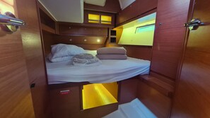 A compact, wooden interior with a bunk bed, a small window, and a door with a handle. - Dubrovnik Delight: A Sun-Kissed Sailing Experience (Komolac)