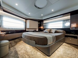 A modern bedroom with a curved bed, built-in storage, and large windows. - Sun-Kissed Sailing Adventure in Sibenik, Croatia (Rogoznica)