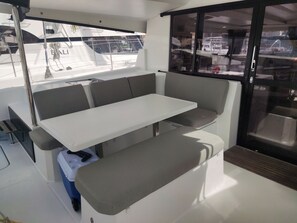 A modern interior with a white table and grey seating, large windows, and a sliding door.