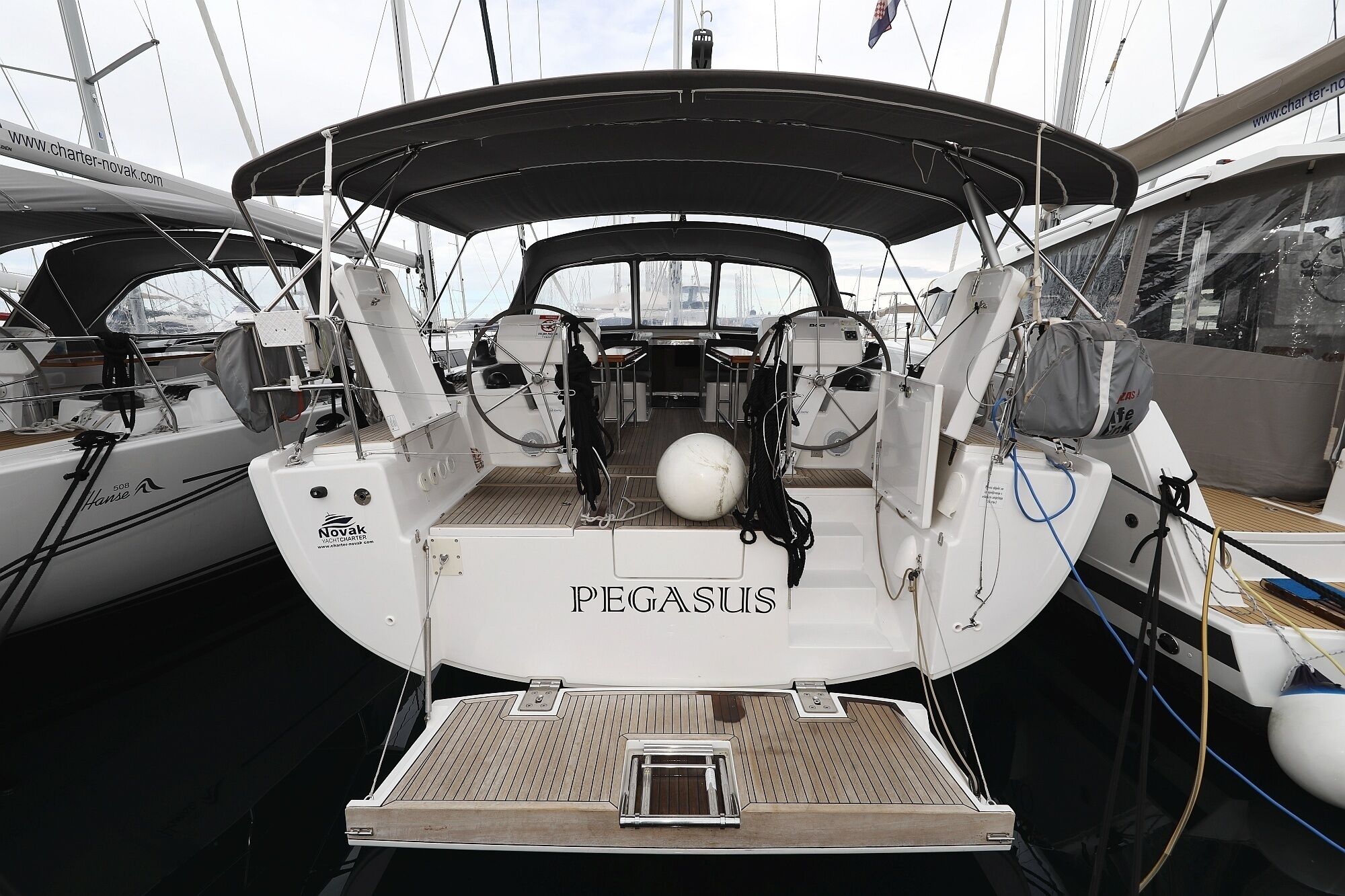 En yacht vid namn PEGASUS, utrustad med ett täckt däck, ett ratt och en vinsch.