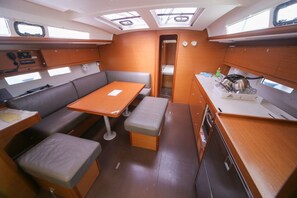 A compact galley with a table, bench seating, and a small kitchenette. - Sun-kissed Sailing Adventure in Split-Dalmatia, Croatia (Seget Donji)