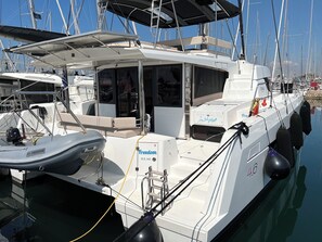Ein Yachthafen mit mehreren vertäuten Booten, darunter ein weißes Boot mit der Aufschrift 'Freedom' und 'N.E. 342', sowie ein kleineres Boot mit 'TT FREEDOM' an der Seite.
