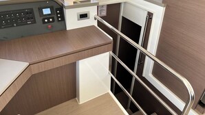 A control panel with various buttons and a digital display, a small table with a lamp, and a potted plant. - Sun-Kissed Sailing Adventure in Islas Sarónicas (Alimos)