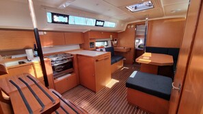 A compact galley with a stove, sink, and a small seating area. - Sun-kissed Sailing Adventure in Split-Dalmatia, Croatia (Trogir)