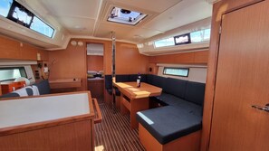 Un interior compacto y bien iluminado con comedor, asientos y una pequeña kitchenette.