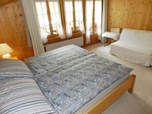 A wooden room with a bed, a small table, and a chair. - Abendrot Appartement/Fewo, Dusche oder Bad, WC 2-Bettwohnung by Interhome (Gstaad)
