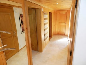 A hallway with wooden doors and a tiled floor. - Abendrot Appartement/Fewo, Dusche oder Bad, WC 2-Bettwohnung by Interhome (Gstaad)
