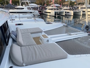 A marina with multiple boats docked, featuring a covered area with seating and a sheltered deck.