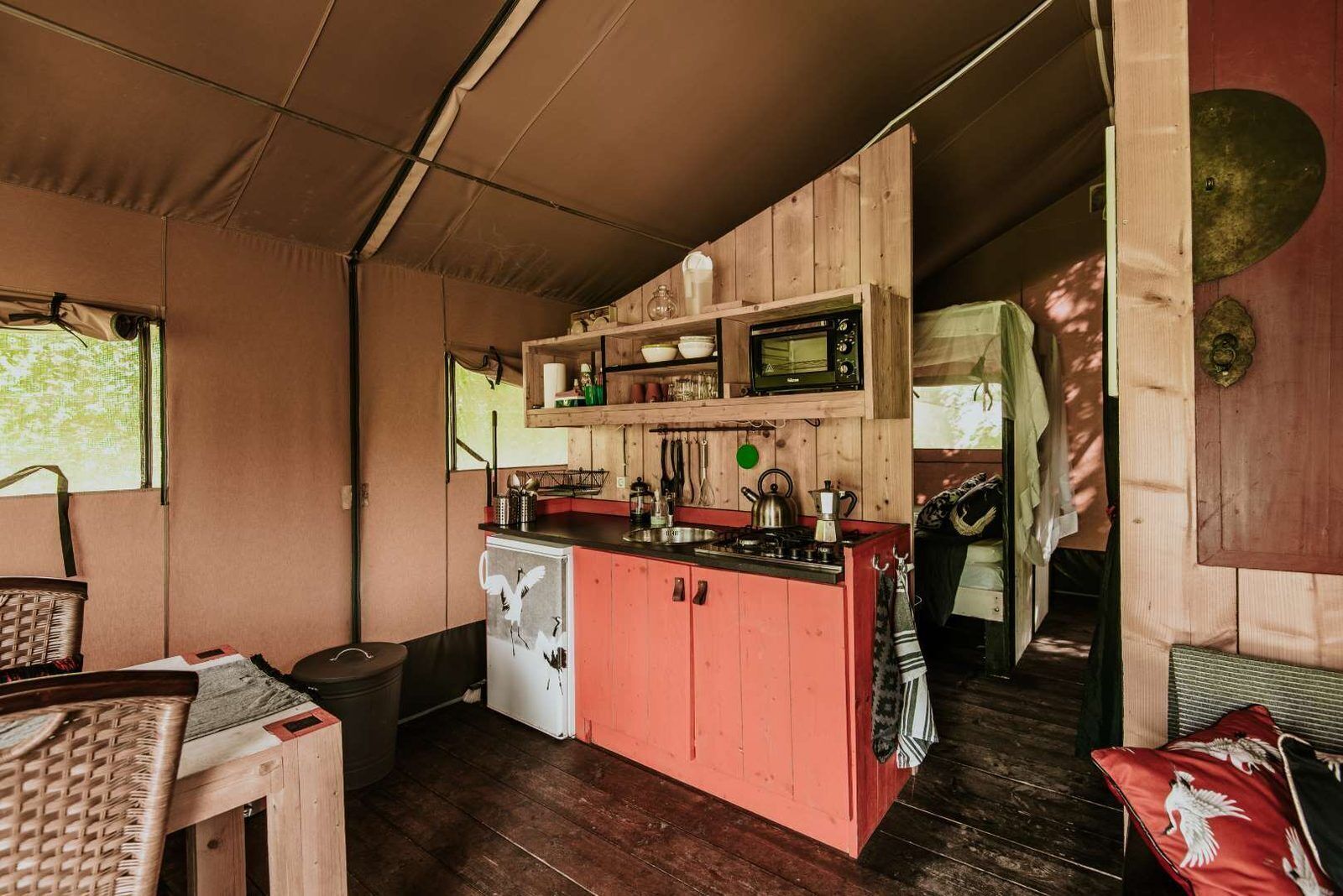 Une cuisine de taille réduite équipée d’un four à micro-ondes, d’une cuisinière et de meubles de rangement en bois.