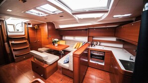 Un interior compacto y bien iluminado con kitchenette, zona de estar y tragaluces.